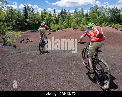 Mountain bike in un ex cratere vulcanico vicino al 'Puy de la Vache' (1167 m). Il vulcano nel Massiccio Centrale appartiene alla 'Chaîne des Puys', la catena montuosa dei Puys con 80 vulcani. Foto Stock