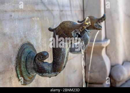 Rubinetto d'acqua in metallo medievale con elementi religiosi e forma di drago. Foto Stock