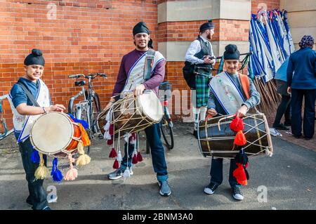 I giocatori di Punjabi dhol si esibiscono al Green Street Diversity Procession, Green Street, Newham, Londra Foto Stock