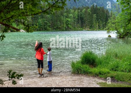 Europa, Germania, Baviera, Alpi, Berchtesgaden, Ramsau, madre e figlio si trovano all'Hintersee vicino a Ramsau e guardano l'acqua Foto Stock