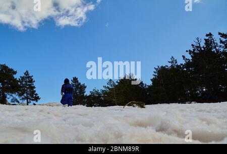 Ragazzo che gioca nella neve in una giornata invernale intensa. Sport nella natura Foto Stock