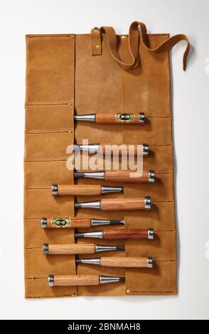 Un set di scalpelli in legno con custodia in pelle, registrazione di oggetti su bianco, strumento in serie per la lavorazione del legno dal Giappone, utensile giapponese per la lavorazione del legno Foto Stock