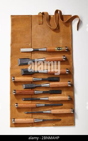 Un set di scalpelli con custodia in pelle, registrazione di oggetti su bianco, strumento in serie per la lavorazione del legno dal Giappone, utensile giapponese per la lavorazione del legno Foto Stock