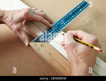 Progetto di parete DIY 02, produzione passo-passo fai-da-te, varie aree turchesi colorate separate da strisce di legno bianco, passo 07: Contrassegnare i punti di fissaggio con un angolo di falegname e una matita Foto Stock