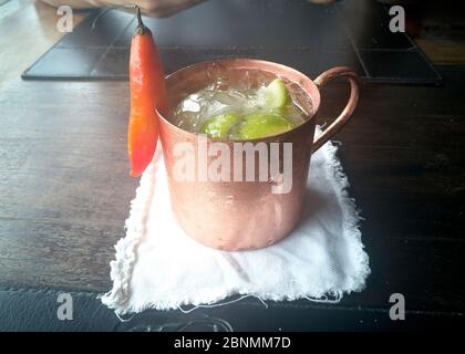 Vetro di metallo con ghiaccio e bevanda, Caipirinha, tavolo marrone, ghiaccio Foto Stock