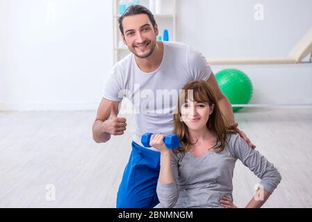 Donna che fa esercizi sportivi con allenatore personale Foto Stock