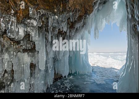 Grotta riempita di ghiaccioli / stalattiti di ghiaccio, il lago Baikal, Siberia, Russia, marzo 2015. Foto Stock