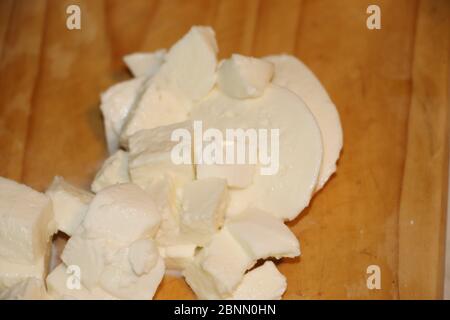 Fette di mozzarella di bufala su fondo di legno. Foto Stock