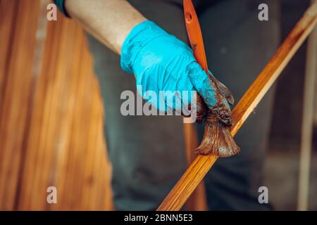 verniciatura di doghe di legno con rivestimento protettivo con tonalità cromatiche Foto Stock