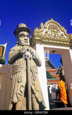 Monaco di Bugghist che cammina attraverso il cancello, Wat Pho tempio, Bangkok, Thailandia Foto Stock