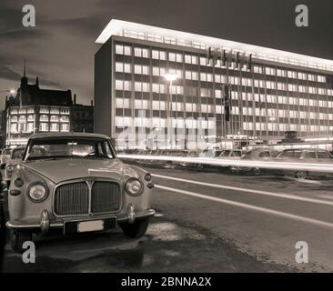 Fiera d'autunno 1964 a Lipsia, atmosfera serale sul mercato di fronte all'edificio espositivo sotterraneo, dietro l'ufficio espositivo di recente costruzione di Lipsia e il grande magazzino Progress Foto Stock