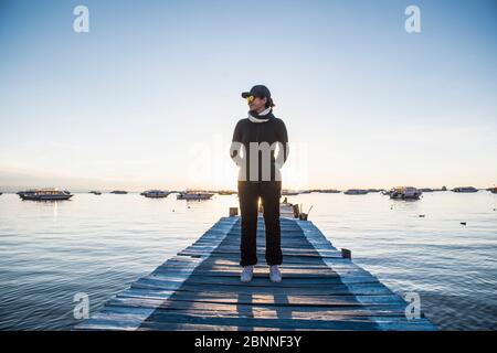 Woman standing on pier at Lake Titicaca, Copacabana, Bolivia Stock Photo