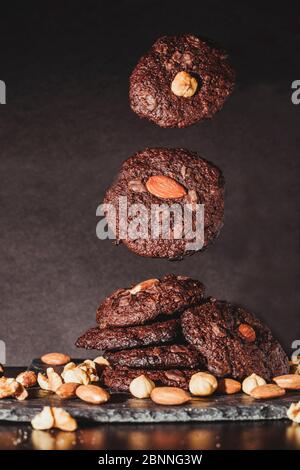 Deliziosi biscotti fatti in casa con scaglie di cioccolato e noci che cadono. Foto Stock