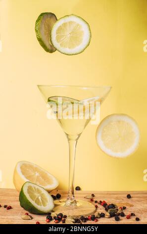Fettine di limone e lime levitanti su fondo giallo. Foto Stock