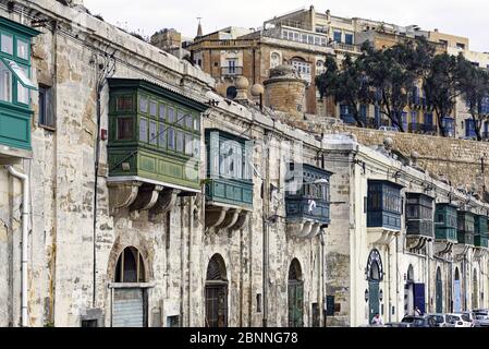 Facciate tipiche di case con balconi colorati vicino al porto di Valletta Foto Stock