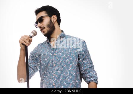 Giovani uomini che portano UN microfono indossando un bicchiere e cantando UNA canzone Foto Stock