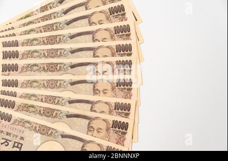 Primo piano di 100,000 yen impilati in strati di banconote da 10,000 yen. Isolato su sfondo bianco. Spazio di copia. Shot orizzontale. Foto Stock