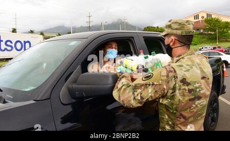 Un soldato della Guardia Nazionale delle Hawaii consegna una scatola di generi alimentari alle famiglie che soffrono della COVID-19, pandemia di coronavirus 24 aprile 2020 a Wailuku, Hawaii. Foto Stock