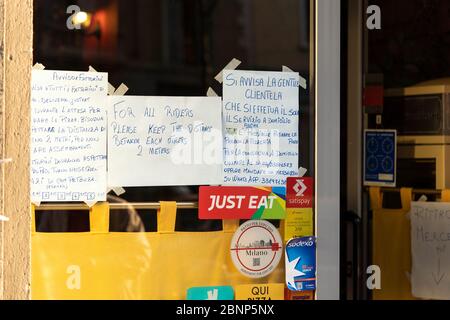 Milano, Italia - 8 maggio 2020: Annuncio fuori dal bar durante lo scoppio del coronavirus circa la distanza sociale. Tentare di arrestare la diffusione di covid-19. DIN Foto Stock