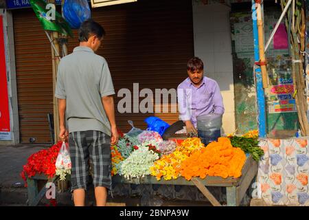 Un uomo che vende fiori sul ciglio della strada Foto Stock