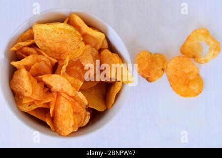 Primo piano di patatine o patatine fritte in recipiente su sfondo bianco/snack piccante malsano Foto Stock