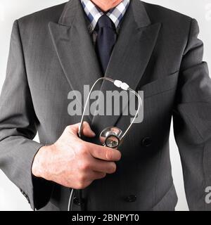Consulente medico maschile indossando tuta intelligente e stetoscopio di tenuta con cravatta ad arco Foto Stock