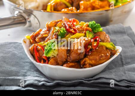 Ciotola di pollo teriyaki cosparsa di semi di seesamo, peperoncini freschi e broccoli. Foto Stock
