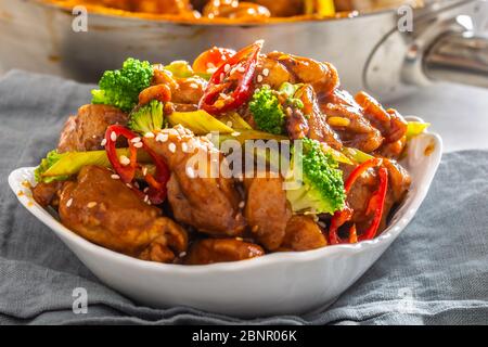Ciotola di pollo teriyaki cosparsa di semi di seesamo, peperoncini freschi e broccoli. Foto Stock