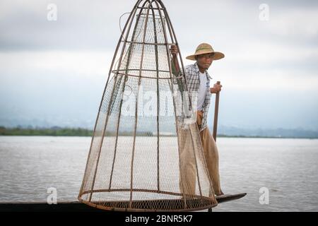 Inle Lake Myanmar - 2 novembre 2013; Ritratto di pescatore che tiene unico stile conico rete pronta per l'uso da barca stretta. Foto Stock