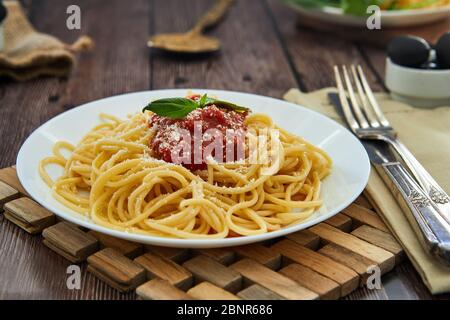 Gustoso e colorato sfizioso spaghetti alla italiana con salsa di pomodoro bolognese e basilico fresco. Foto Stock