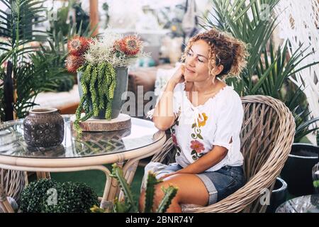 Caucasica felice donna rilassata. Godendo il giardino a casa - piante e fiori negozio concetto negozio con molto varietà e tipi - persone e natura concetto Foto Stock