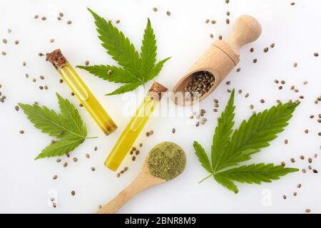 Olio del CBD e semi su sfondo chiaro . Olio cbd di marijuana medica. Disposizione piatta, vista dall'alto Foto Stock