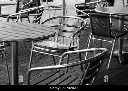 Tavoli da giardino allineati su una terrazza deserta Foto Stock