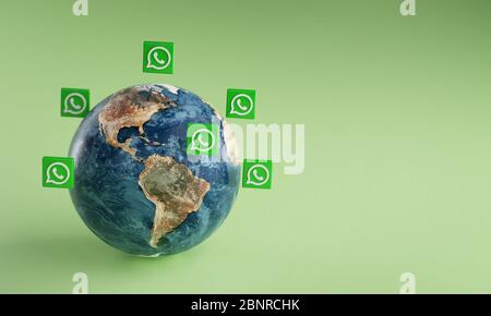 Icona del logo WhatsApp intorno alla Terra. Concetto di app popolare. Foto Stock