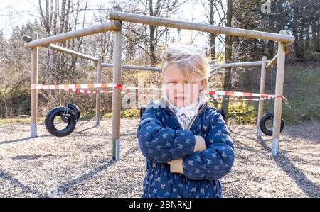 Bambino di fronte a un parco giochi chiuso durante la crisi di Corona 2020 Foto Stock