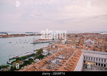 Vista aerea dall'enorme campanile della cattedrale Campanile di San Marco su Santa Maria - della - Salute - Chiesa nel nome di Santa Maria il Salvatore, cielo del tramonto Foto Stock