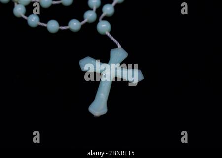 santo rosario isolato su sfondo nero, concetto religioso Foto Stock