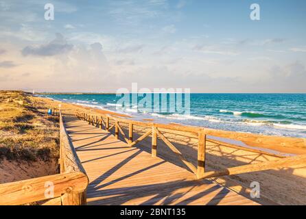 Paesaggio della passerella in legno per accedere alla spiaggia in estate . Guardamar Alicante, Spagna Foto Stock