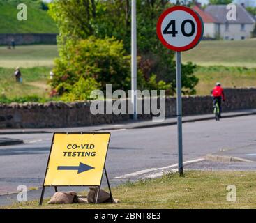 Cockenzie, East Lothian, Scozia, Regno Unito. 16 maggio 2020. Stazione di test Covid-19: Ex stazione di potenza di Cockenzie, acquistata da East Lothian Council da Scottish Power, apre oggi come drive-through COVID-19 centro di test. È gestito dai militari (51 ° Brigata di Fanteria) per i lavoratori di chiave o un membro della loro famiglia con sintomi. Funziona come una struttura autonoma e drive-through con persone che rimangono nel veicolo durante i test come parte della strategia di test, tracciamento e isolamento del governo scozzese. Un ciclista passa oltre il cartello temporaneo Foto Stock
