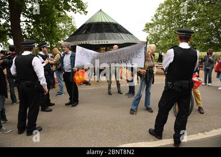 La polizia parla con i manifestanti di Hyde Park a Londra dopo l'introduzione di misure per far uscire il paese dalla situazione di blocco. Foto Stock