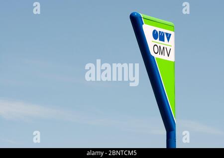 Stazione di servizio OMV o stazione di servizio o logo della stazione di servizio e cartello isolato contro il cielo blu Foto Stock