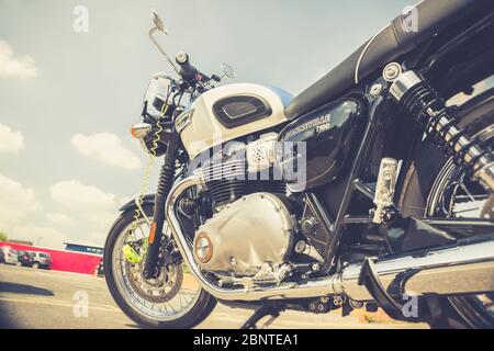 Chiudi Triumph Bonneville T100 moto (moto) parcheggiato poggiando sul poggiapiedi all'aperto sotto il sole del Regno Unito. Motociclette del Regno Unito. Foto Stock