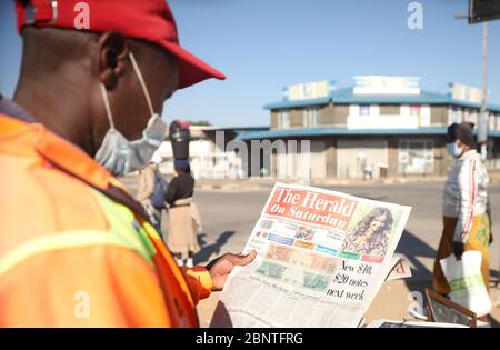 (200516) -- HARARE, 16 maggio 2020 (Xinhua) -- una persona guarda le illustrazioni delle nuove banconote su un giornale ad Harare, Zimbabwe, 16 maggio 2020. La Reserve Bank of Zimbabwe (RBZ) ha dichiarato venerdì introdurrà una nuova nota da 10 dollari dello Zimbabwe il 19 maggio, seguita da una nota da 20 dollari nella prima settimana di giugno, nell'ambito di misure volte ad aumentare l'offerta di denaro fisico e a contenere le carenze di contanti. (Foto di Shaun Jusa/Xinhua) Foto Stock
