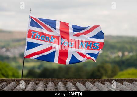 Newport, Galles, Regno Unito. 16 maggio 2020. Una bandiera di union jack con lo slogan grazie NHS, soffia nel vento sopra un tetto durante la pandemia di Coronavirus Covid-19 nel Regno Unito. Credit: Tracey Paddison/Alamy Live News Foto Stock