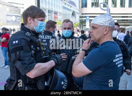 16 maggio 2020, Hessen, Francoforte sul meno: I poliziotti hanno dato un rappresone a un uomo con un cappello in alluminio sulla testa dopo aver cercato di interferire con i partecipanti di un rally contro una dimostrazione di destra. Foto: Boris Roessler/dpa Foto Stock