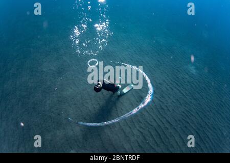 Freediver subacqueo che soffia anelli bolla nelle acque poco profonde di Tenerife, Isole Canarie, Spagna.
