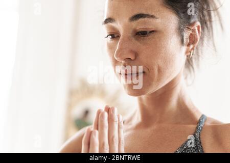 Immagine di una giovane concentrata sorprendente forte donna fitness al chiuso a casa meditare mantenere la calma. Foto Stock