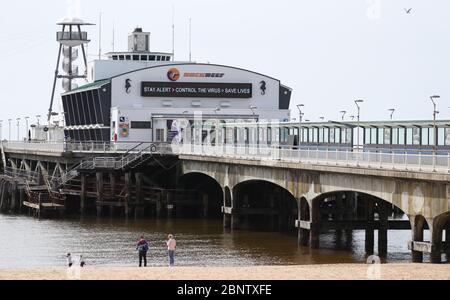 Un segno che dice 'allarme di giorno, controllo del virus, salvare vite' è visto sul molo di Bournemouth, dopo l'introduzione di misure per portare il paese fuori di blocco. Foto Stock