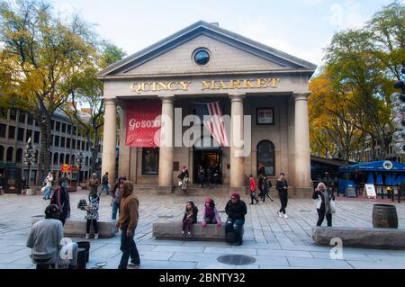 Boston, Massachusetts. 30 ottobre 2018. La gente outside Quincy mercato con un banner rosso sox e bandiera americana appeso tra i pilastri degli edifici o Foto Stock