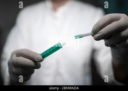 Infermiere che contiene una siringa e un contenitore per vaccino. Foto Stock